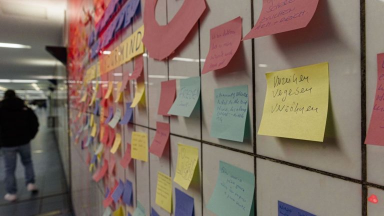 Aktion mit Klebezetteln: „Frieden“ – Menschen kleben Post-It’s gegen Einsamkeit